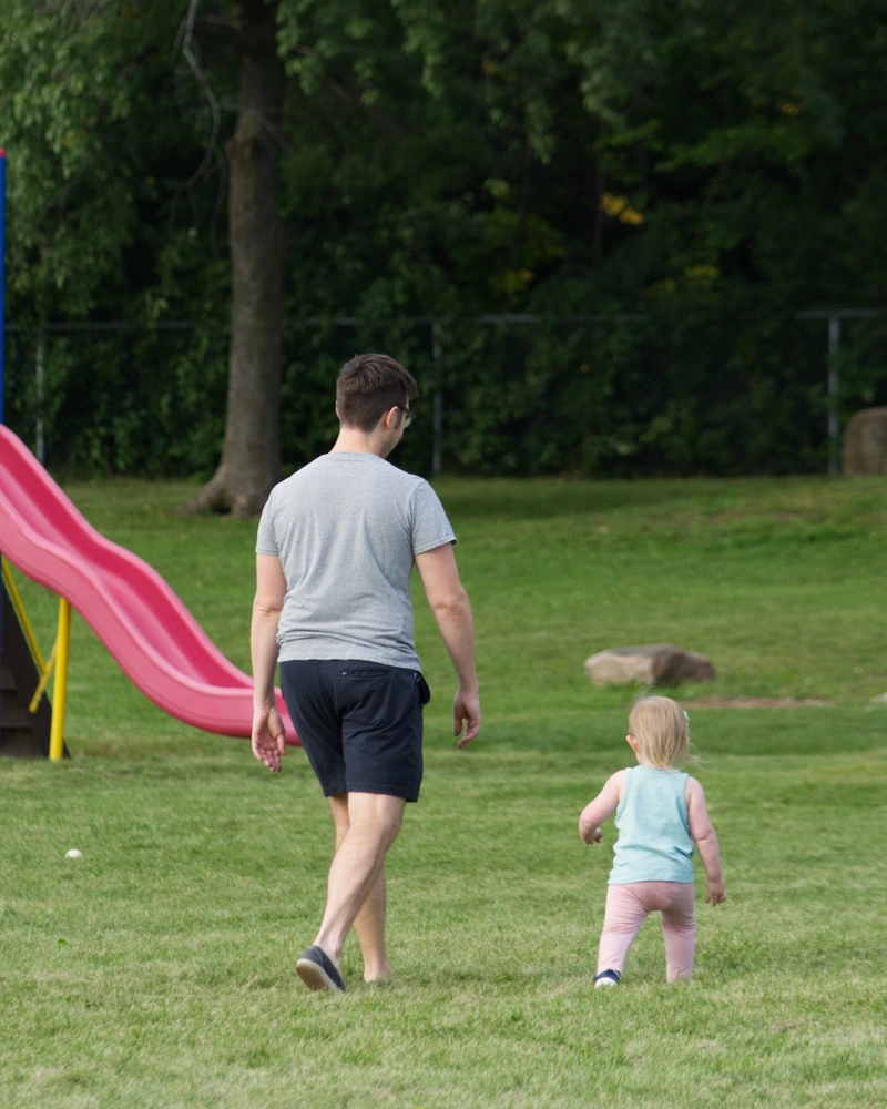 Daniel Pershick walking with his child at a playground